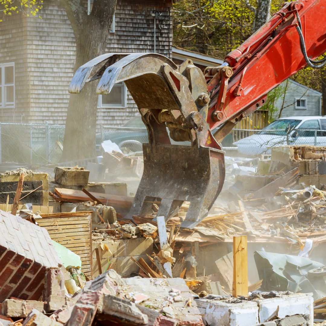 Demolition of an old house, wooden planks and rubble and the ruins of the house for new construction project.